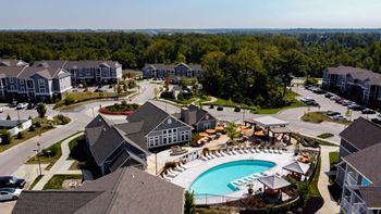 An aerial view of a residential area with houses and a swimming pool.
